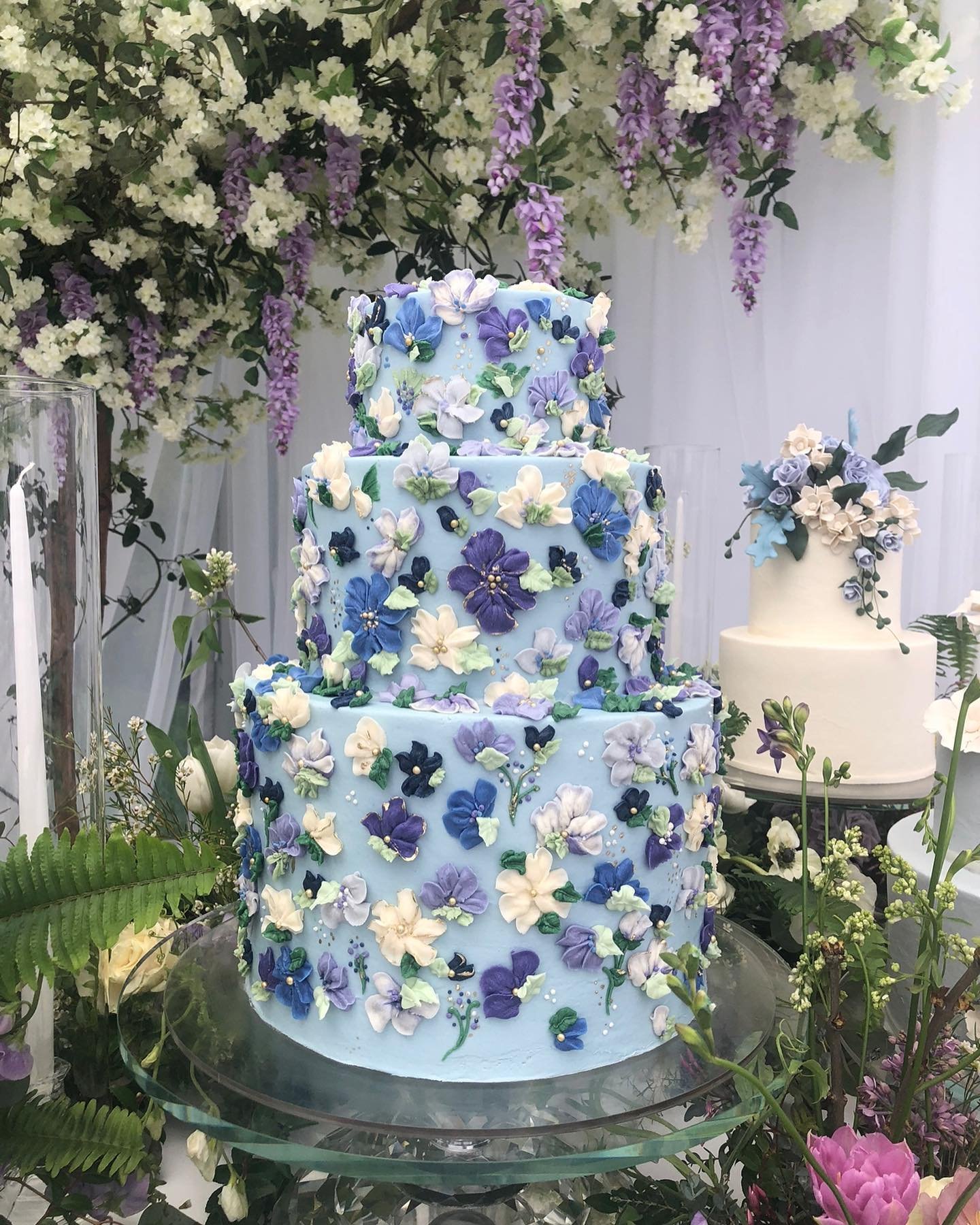 Light blue wedding cake with intricate floral decorations.