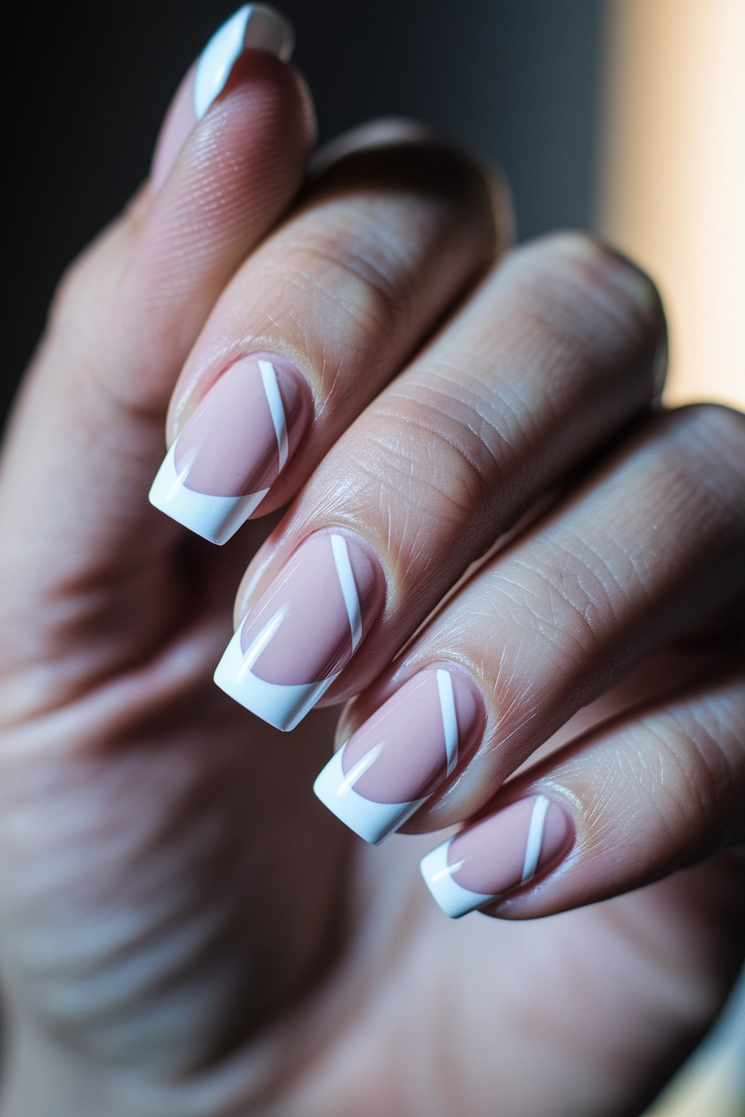 a light pink base, white French tips, and a diagonal white line across each nail.