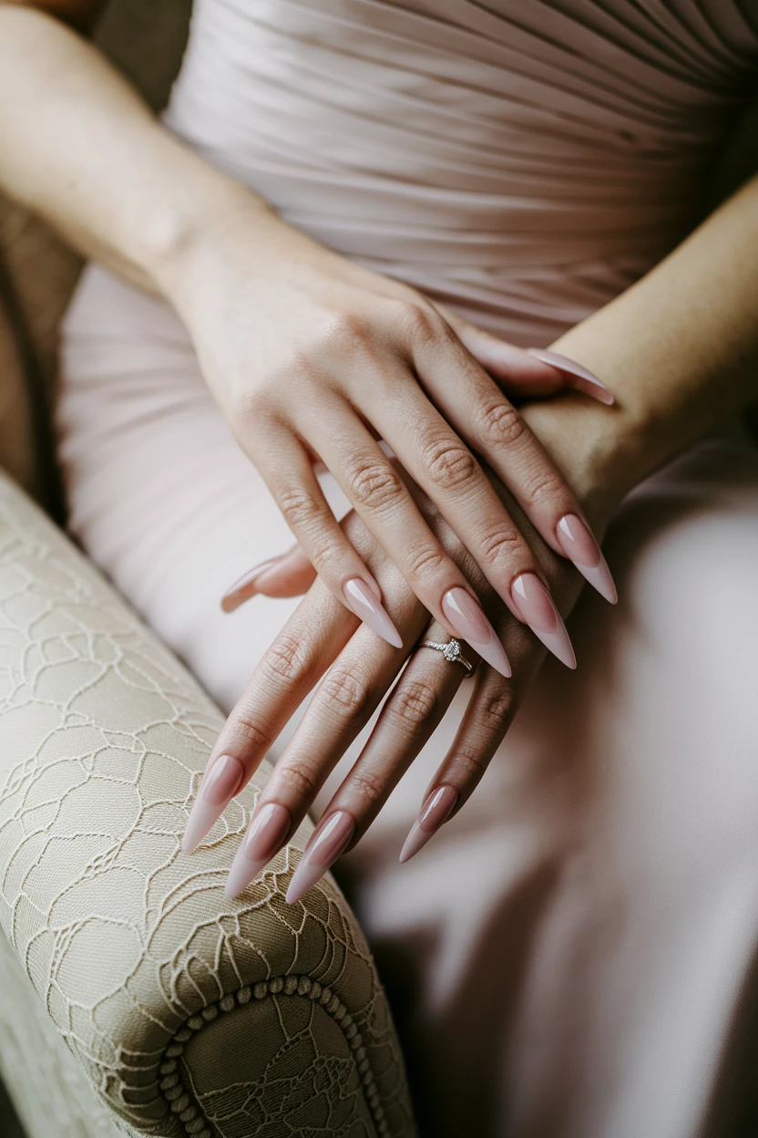 Long nude stiletto nails with silver ring.