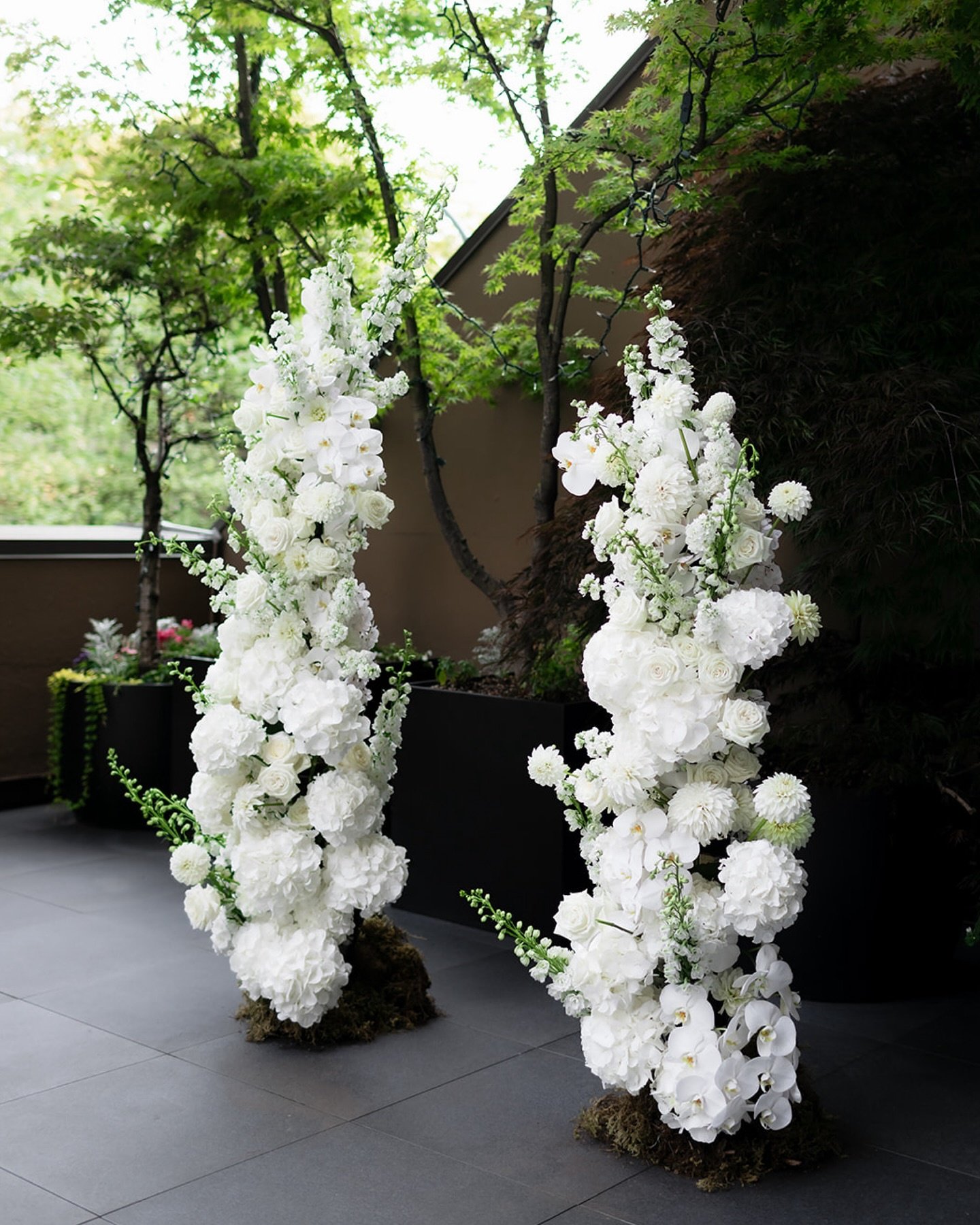 Two tall arrangements of white flowers.