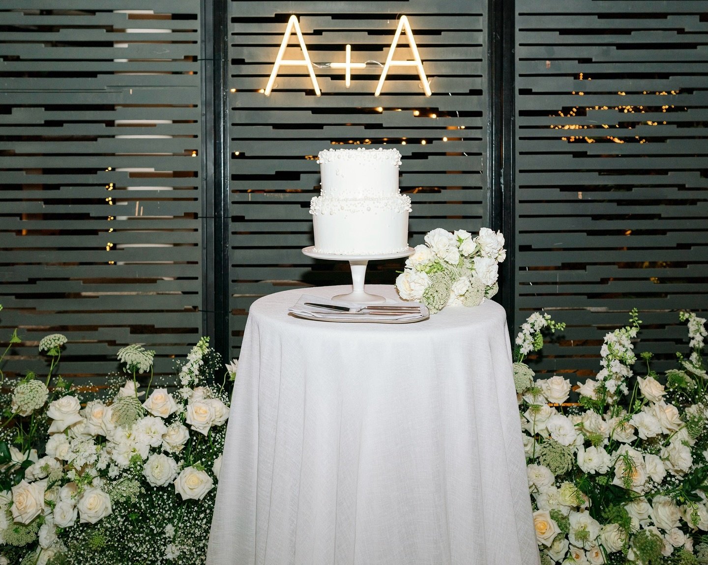 Wedding cake table decorated with white flowers.