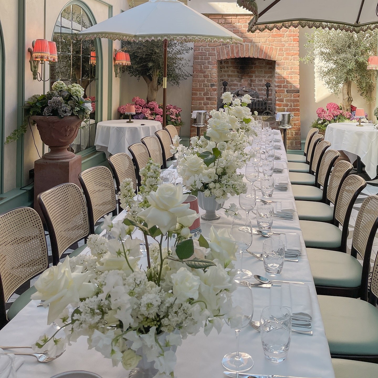 Long wedding table decorated with white floral centerpieces.