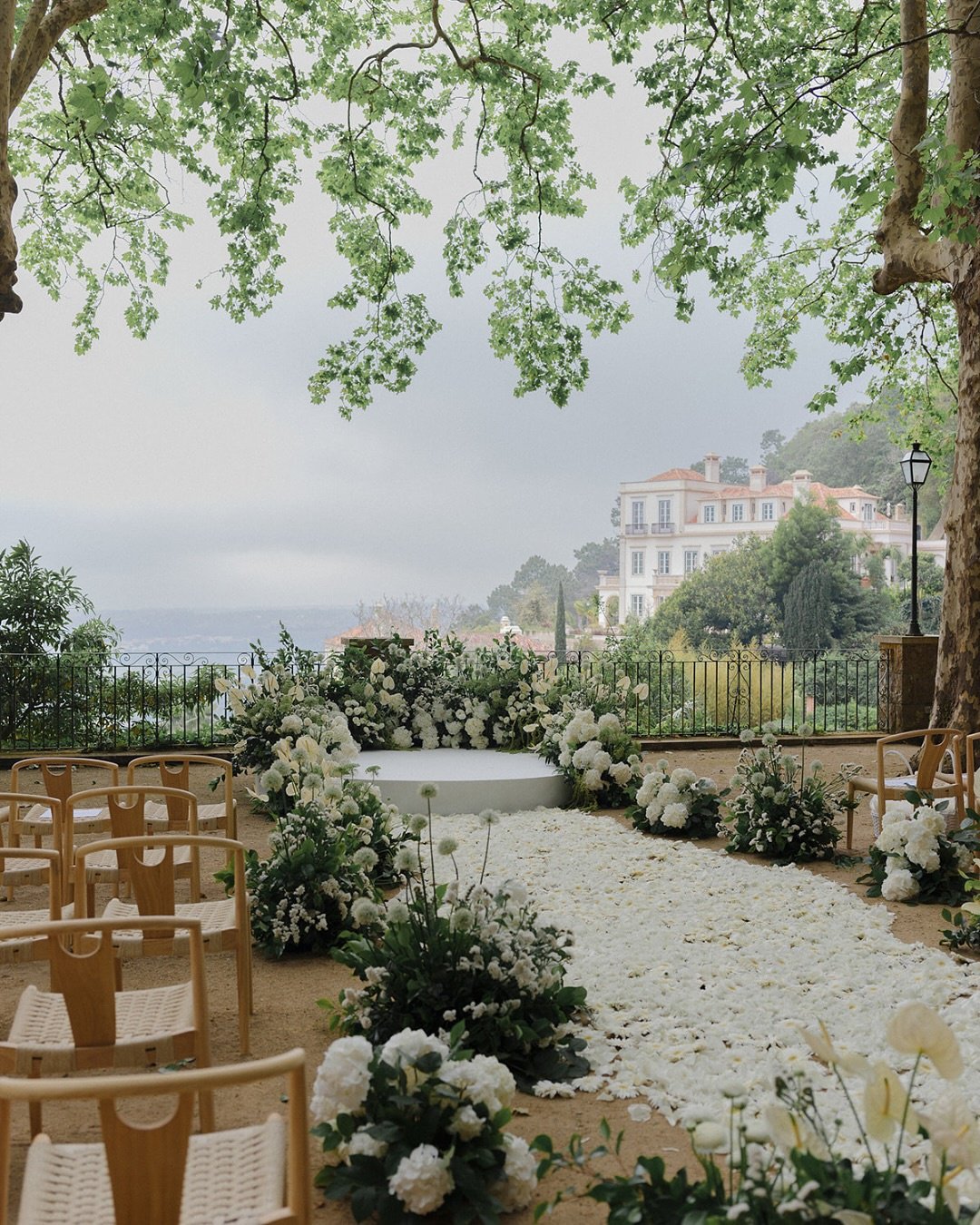 Outdoor wedding ceremony with white flower arrangements.