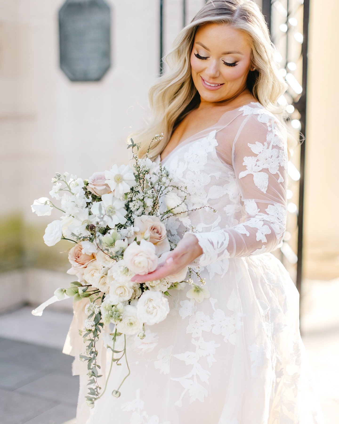 Bride holding a lush bouquet of white and cream flowers.